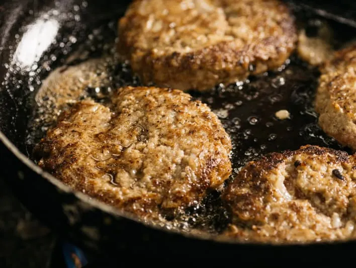 Cooking a hamburger patty in a frying pan.